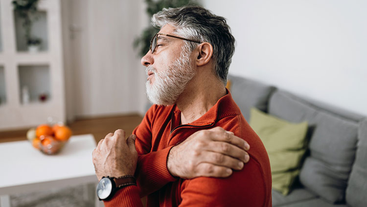 Man holding shoulder in pain